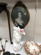 A ceramic bust of a lady and an oval framed portrait print.