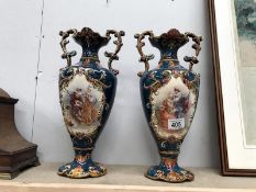A pair of twin handled vases with musician scenes.