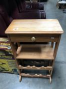 A small kitchen cupboard with drawer and bottle rack plus a folding chair and one other.