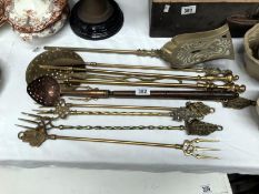A mixed lot of brass fire irons, toasting forks etc.