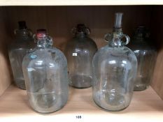 5 large glass wine jars.