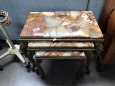 A nest of 3 metal based tables with marble tops.