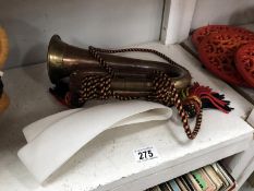 A copper and brass bugle and belt.