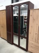 A mahogany effect wardrobe with mirrored doors.