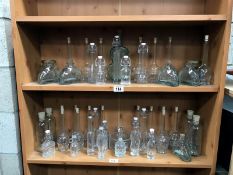 2 shelves of various shaped bottles with stoppers.