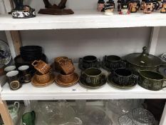 A shelf of Portmerion and Denby pottery.