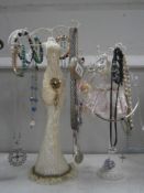 Two figural jewellery stands and collection of costume necklaces and bracelets