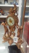 A small gilt metal clock surmounted cherub,