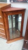 An oak corner cabinet with mirrored back