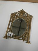 An Edwardian free standing bevel edged mirror in ornate brass frame
