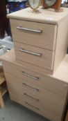 A lightwood effect chest of drawers and a matching beside cabinet