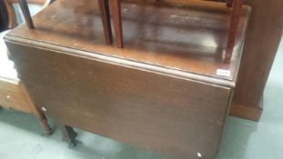 A 1930's oak drop leaf table with tapered legs