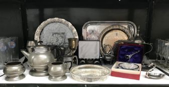 A shelf of plated metalware including trays, napkin trays etc.