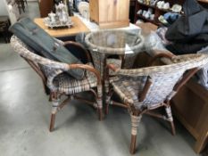 2 colourful cane chairs and a glass top table