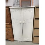 A painted wooden child's wardrobe