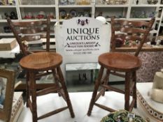 A pair of darkwood tall kitchen chairs