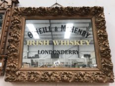 A carved gilt framed mirror with O'Niell & McKenry Irish whiskey Londonderry advertising