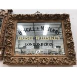 A carved gilt framed mirror with O'Niell & McKenry Irish whiskey Londonderry advertising