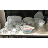 A shelf of 1970's Pyrex dinnerware and a shelf of plated cutlery etc.