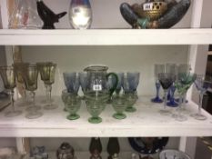 A shelf of coloured drinking glasses