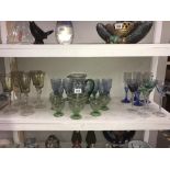 A shelf of coloured drinking glasses