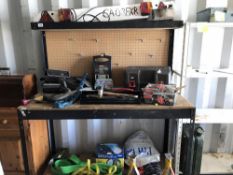 A metal framed work bench with backboard for tool hooks and an overhead shelf