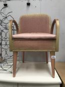 A pink loom carver chair with floral seat