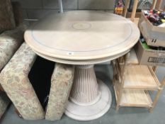 A circular table with shells carved on central column