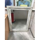 A large painted bevel edge mirror
