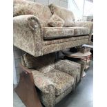 A brown floral 2 seater sofa with matching armchair and footstool