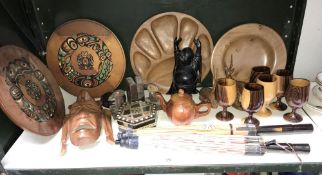 A shelf of wooden carved items including buddah, face mask etc.