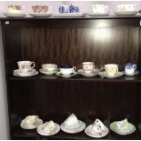 3 shelves of porcelain tea cups and saucers including trios