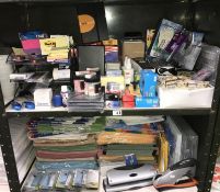2 shelves of office supplies including post it notes, files, staples etc.