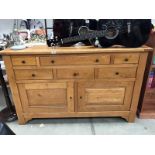 A modern oak sideboard with 6 drawers and 2 cupboards