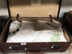 A vintage suitcase with embroidered linens and household textiles