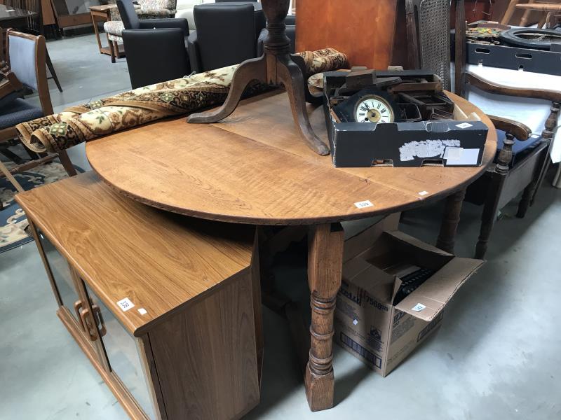 A large oak circular drop leaf table