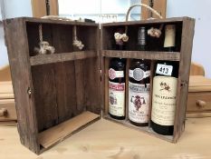 A wooden case containing 3 bottles of 1980's wine