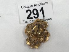 A yellow metal brooch