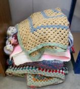 A quantity of knitted and crocheted blankets.