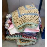 A quantity of knitted and crocheted blankets.