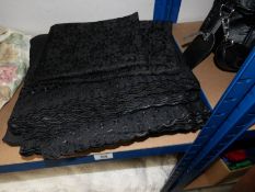 Approximately 10 metres of black fabric with 'broderie Anglais' decoration and a length of black