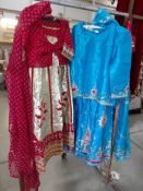 2 ladies Indian outfits comprising skirt, top and shawl, decorated with gold embroidery.