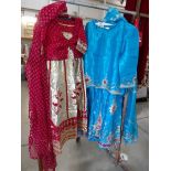 2 ladies Indian outfits comprising skirt, top and shawl, decorated with gold embroidery.