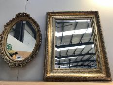 A decorative, oval, gilded mirror, plus 1 other.