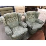 A pair of green upholstered armchairs