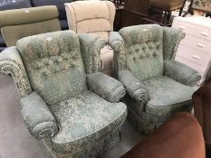 A pair of green upholstered armchairs