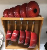 A set of 5 Le Creuset saucepans with rack.