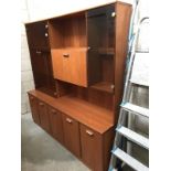 A teak effect wall unit with glass doors