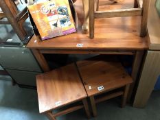 A stained pine table and 2 stools