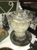 A concrete garden bird bath with urn and lid